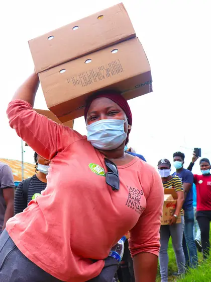 A volunteer carrying boxes of supplies at a community distribution